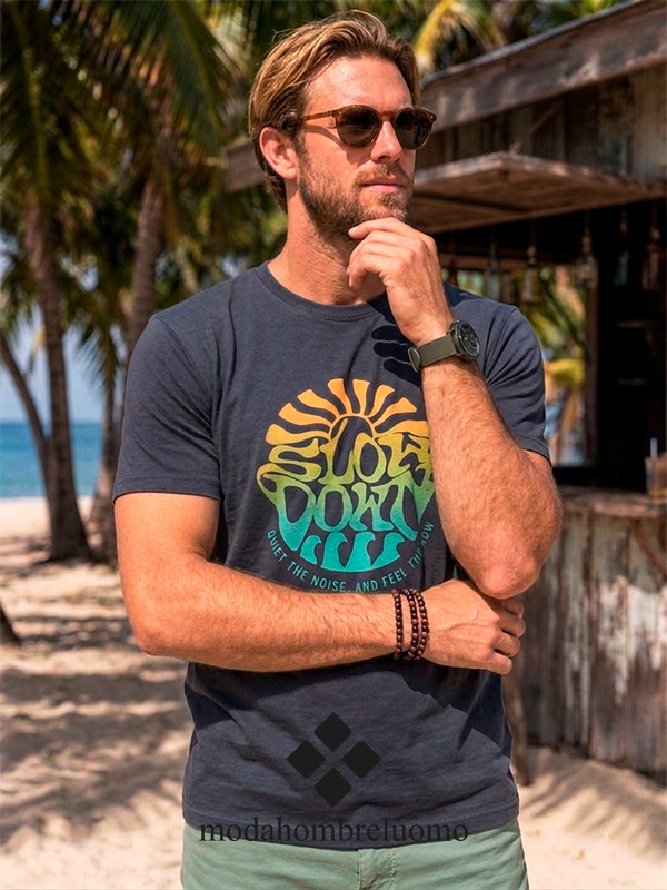 camiseta-hombre-algodón-dibujo-surf---1 Hombre vistiendo camiseta de algodón azul en playa tropical