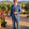 hombre que viste traje elegante verde claro en jardín