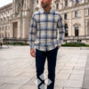 hombre vistiendo camisa de cuadros celeste de la vespita en una plaza de viena