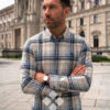 hombre vistiendo camisa de cuadros celeste de la vespita en una plaza de viena