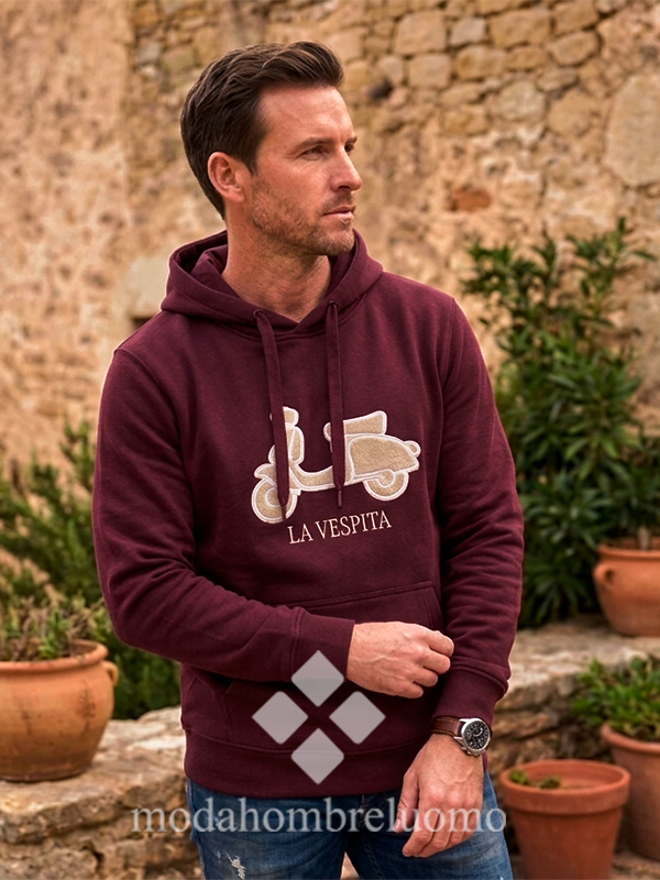 SUDADERA-VESPITA-CAPUCHA-GRANATE-2 hombre vistiendo sudadera de la vespita en color granate en un entorno natural
