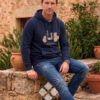 hombre vistiendo sudadera de la vespita en color azul marino en un entorno natural