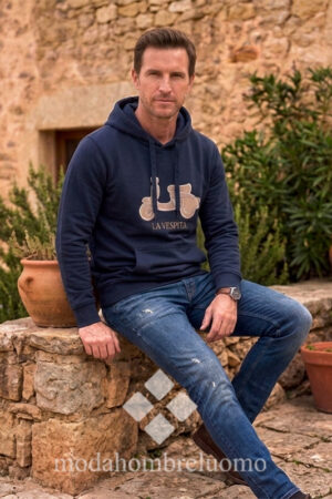 hombre vistiendo sudadera de la vespita en color azul marino en un entorno natural