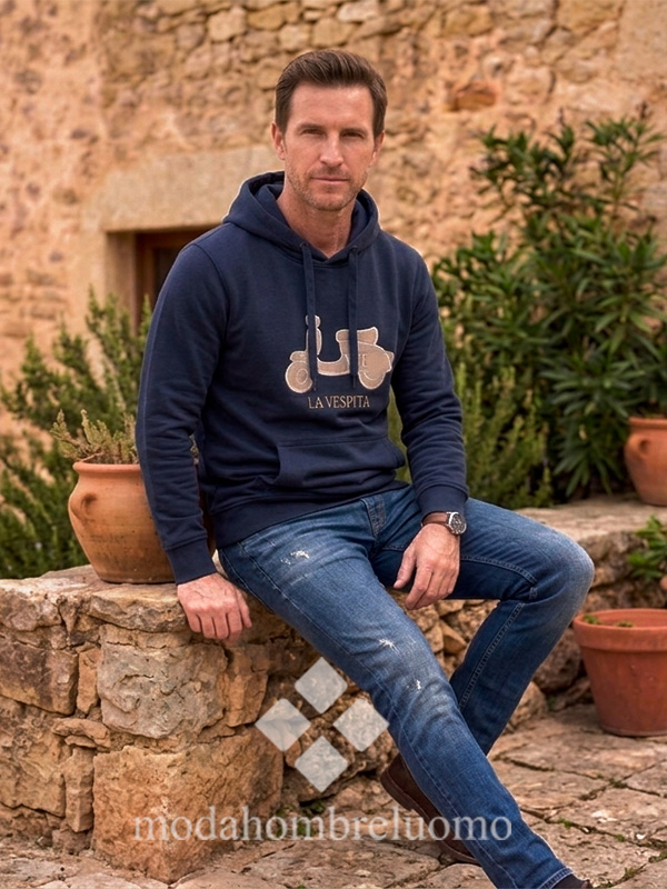 SUDADERA-VESPITA-CAPUCHA-MARINO-3 hombre vistiendo sudadera de la vespita en color azul marino en un entorno natural